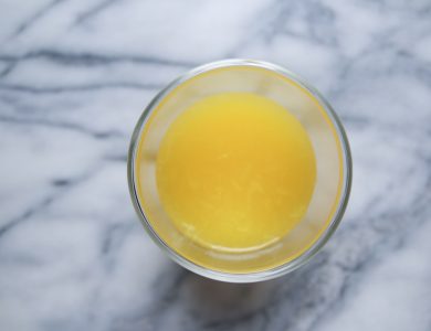 A glass of orange juice on a marble table