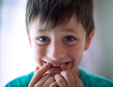 a young boy with a toothbrush in his mouth