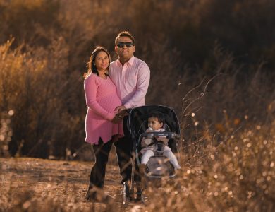 a man and a woman standing next to a baby in a stroller