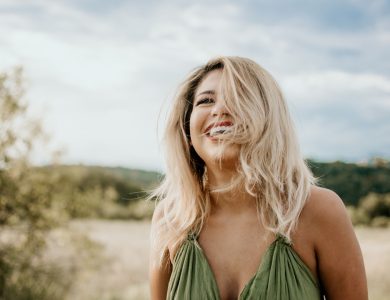 time-lapse photography of laughing woman with hair covering half of her face