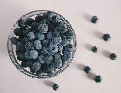 A bowl overflowing with fresh blueberries on a counter.