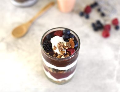 A prepared bowl with fruit, berries, nuts and other meal ingredients.