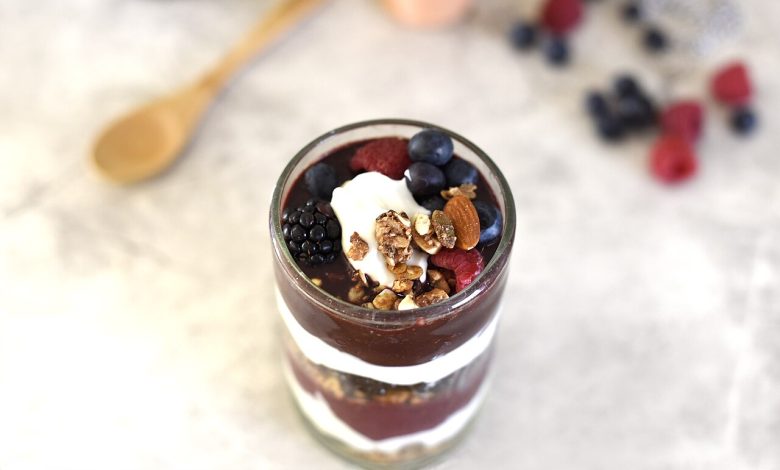 A prepared bowl with fruit, berries, nuts and other meal ingredients.